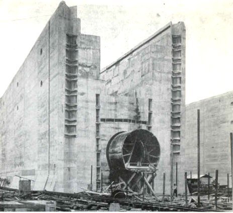 Panama Canal locks under construction in 1910. The worker near the culvert gives the structure its scale. Artist unknown;